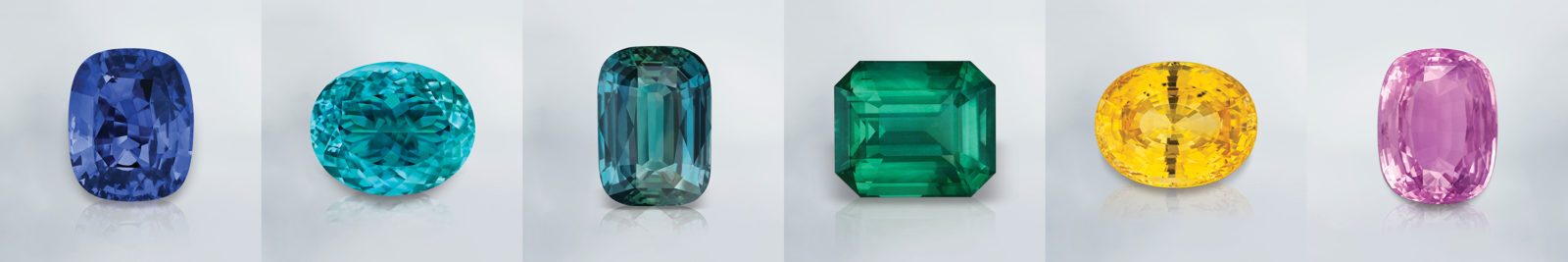 From Left to Right: Pride of Sri Lanka / The Healing Blue (186.82 ct deep royal blue Sapphire from Sri Lanka), The Magnificent (106.20 ct, Paraiba blue Tourmaline from Mozambique), The Miracle (100.06 ct teal Sapphire from Tanzania), The Crown of Colombia (241.04 ct deep electric green Emerald from Colombia), The Sunrise of Ceylon (115.13 ct sunshine yellow Sapphire), The Princess Pink (109.82 ct bubble gum pink Sapphire from Sri Lanka)